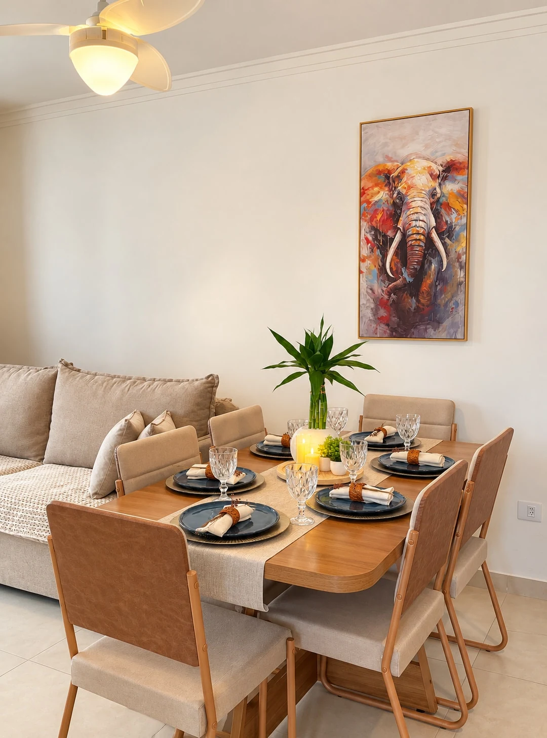 Sala de estar e de jantar com sofá-cama e mesa posta para seis pessoas